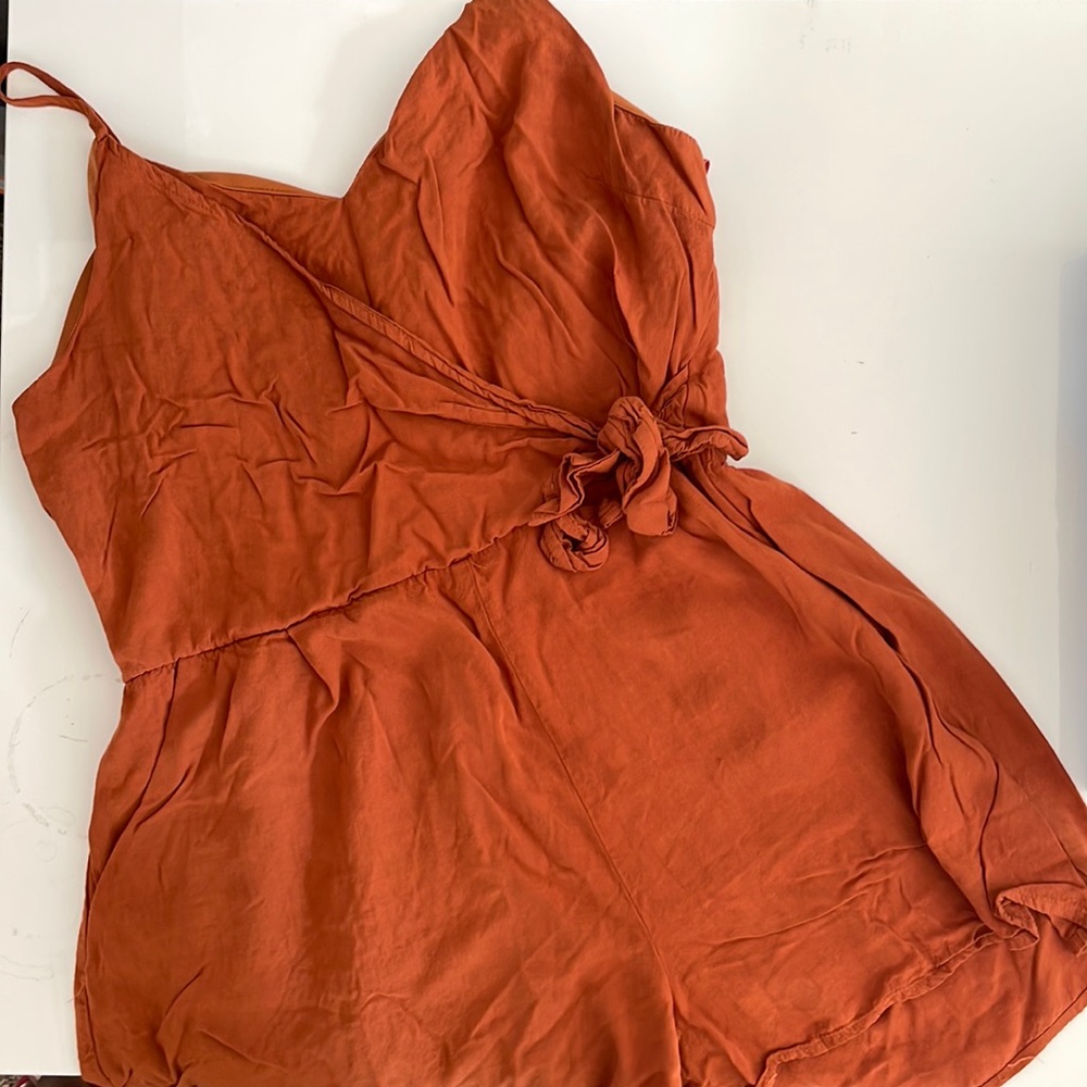 Burnt orange romper with tie on the left side.